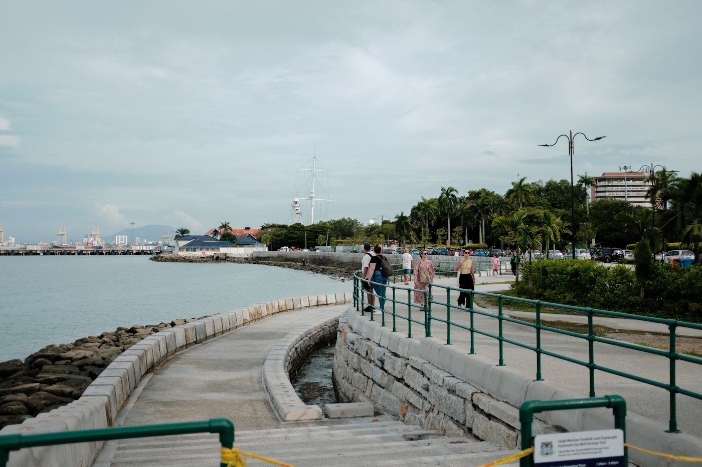 People walking along a waterfront pier in George Town, Penang